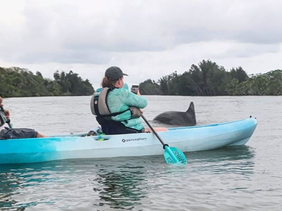 a group of people riding on the back of a boat in the water