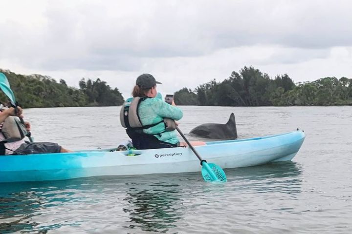 a group of people riding on the back of a boat in the water