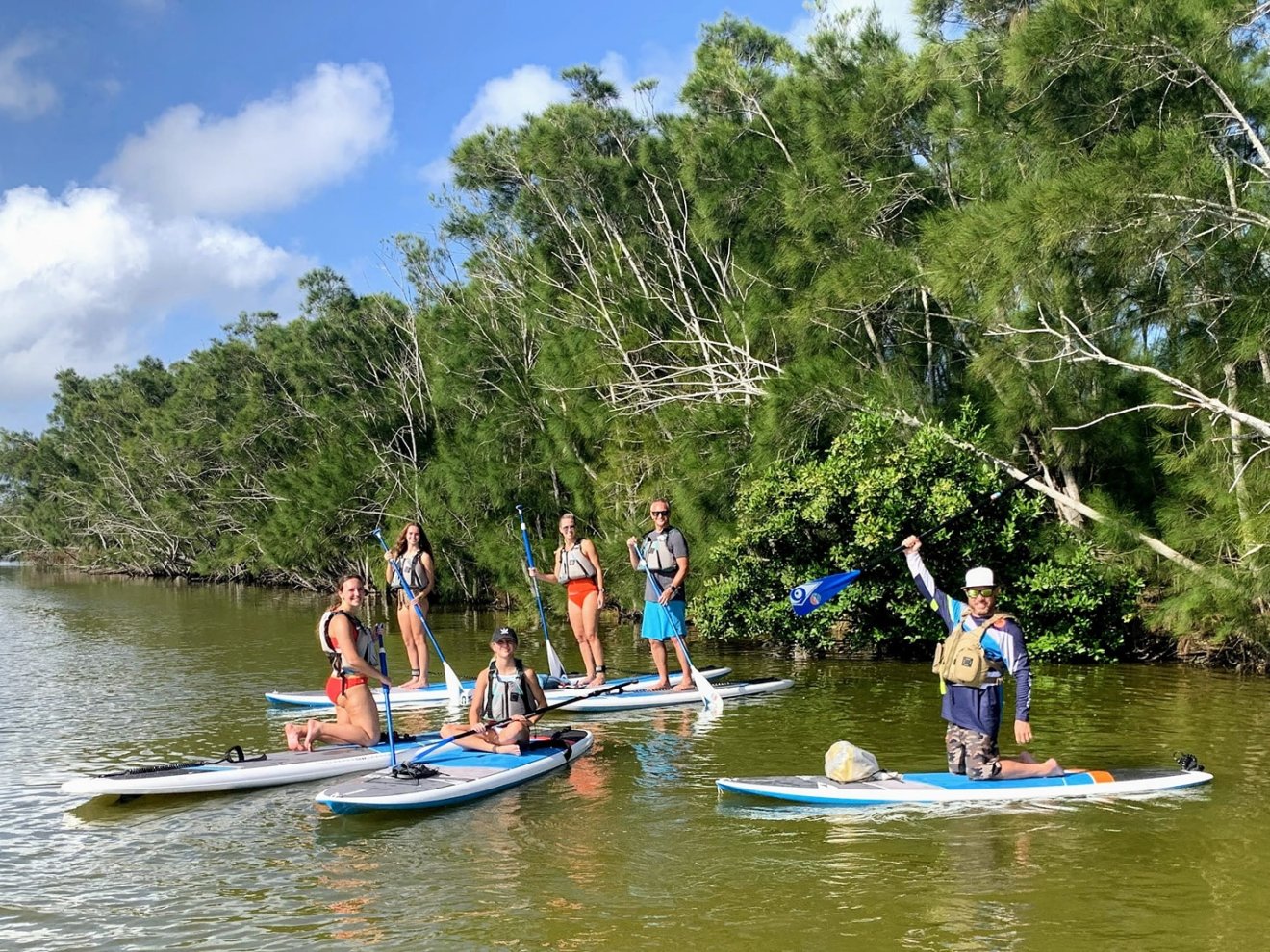 a group of people riding on the back of a boat in the water