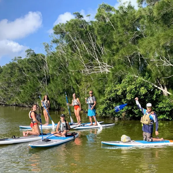 a group of people riding on the back of a boat in the water