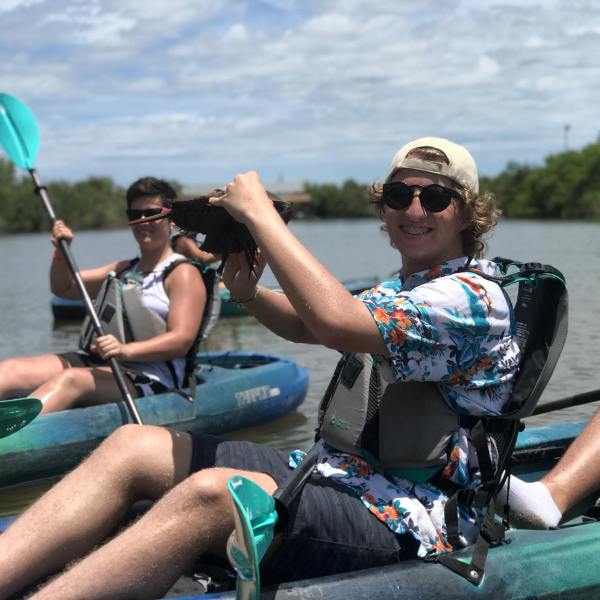 a group of people sitting next to a body of water