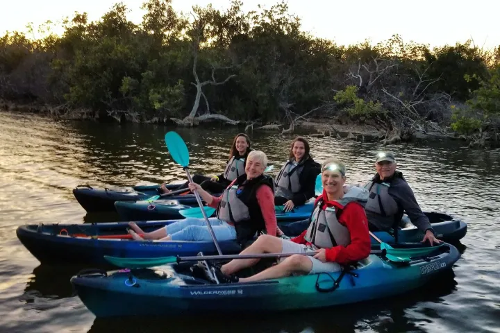 a group of people riding on the back of a boat in the water