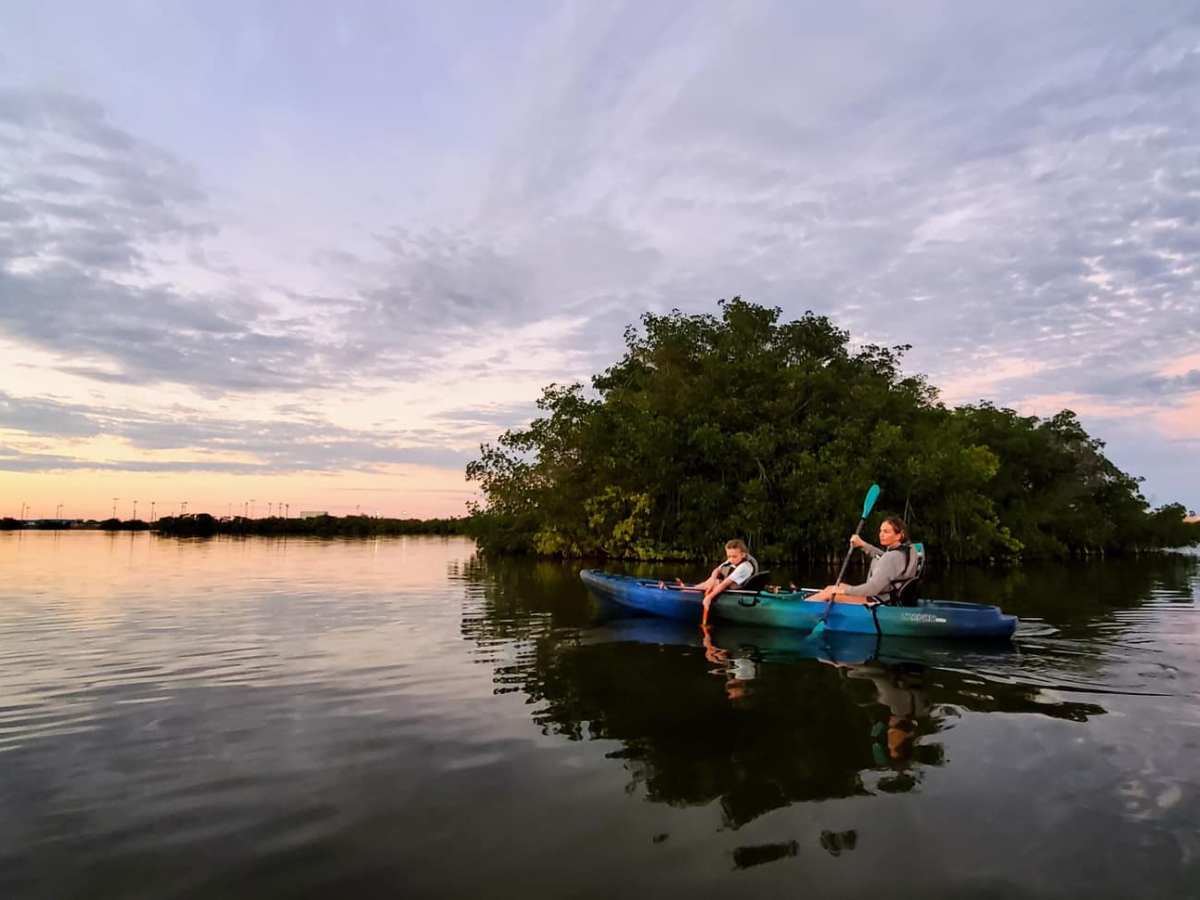 a man riding on the back of a boat in a body of water
