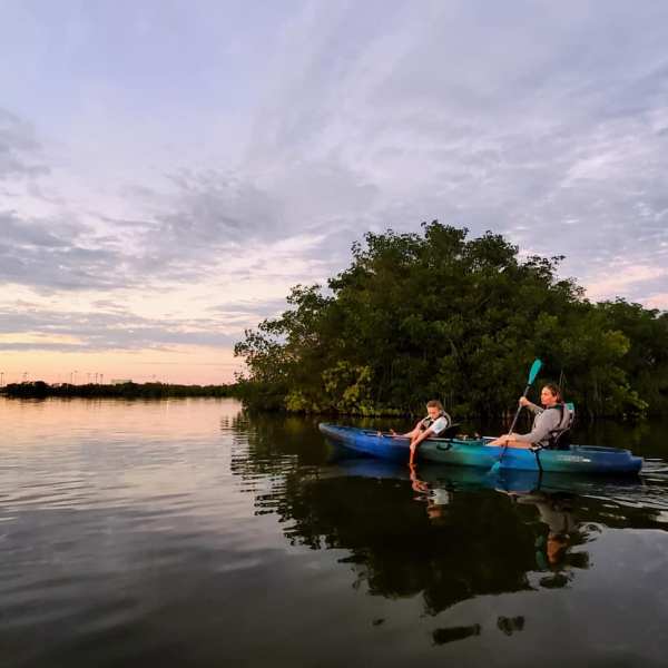 a man riding on the back of a boat in a body of water