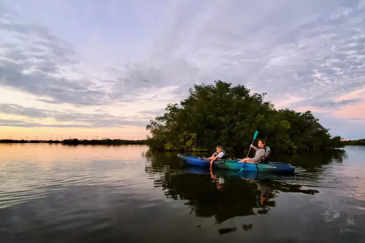a man riding on the back of a boat in a body of water