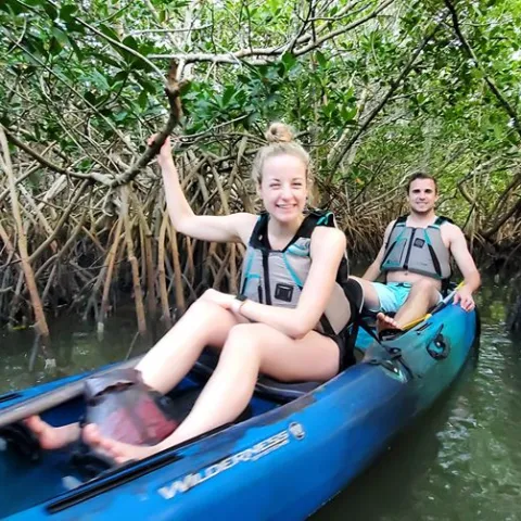 a young girl riding on the back of a boat