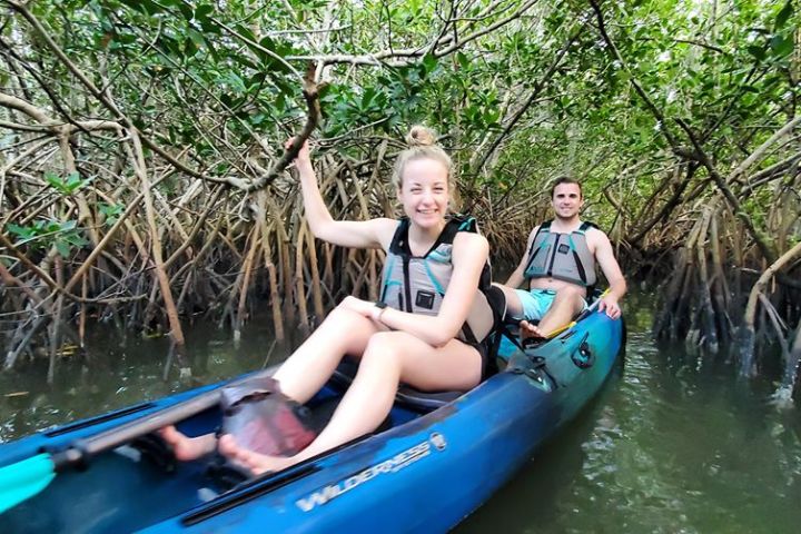 a young girl riding on the back of a boat