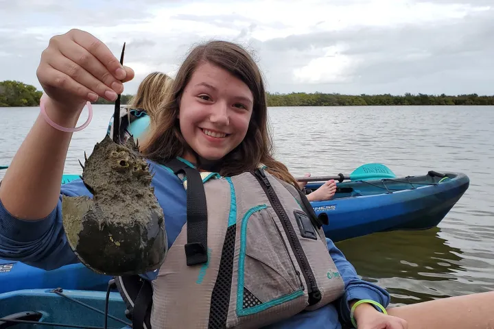a woman sitting on a boat in a body of water