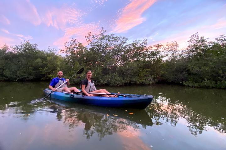 a little girl riding on the back of a boat in the water