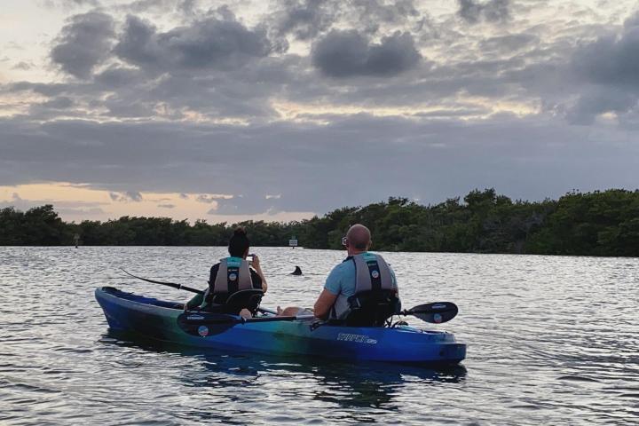 a man riding on the back of a boat in a body of water