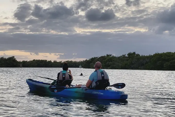 a man riding on the back of a boat in a body of water