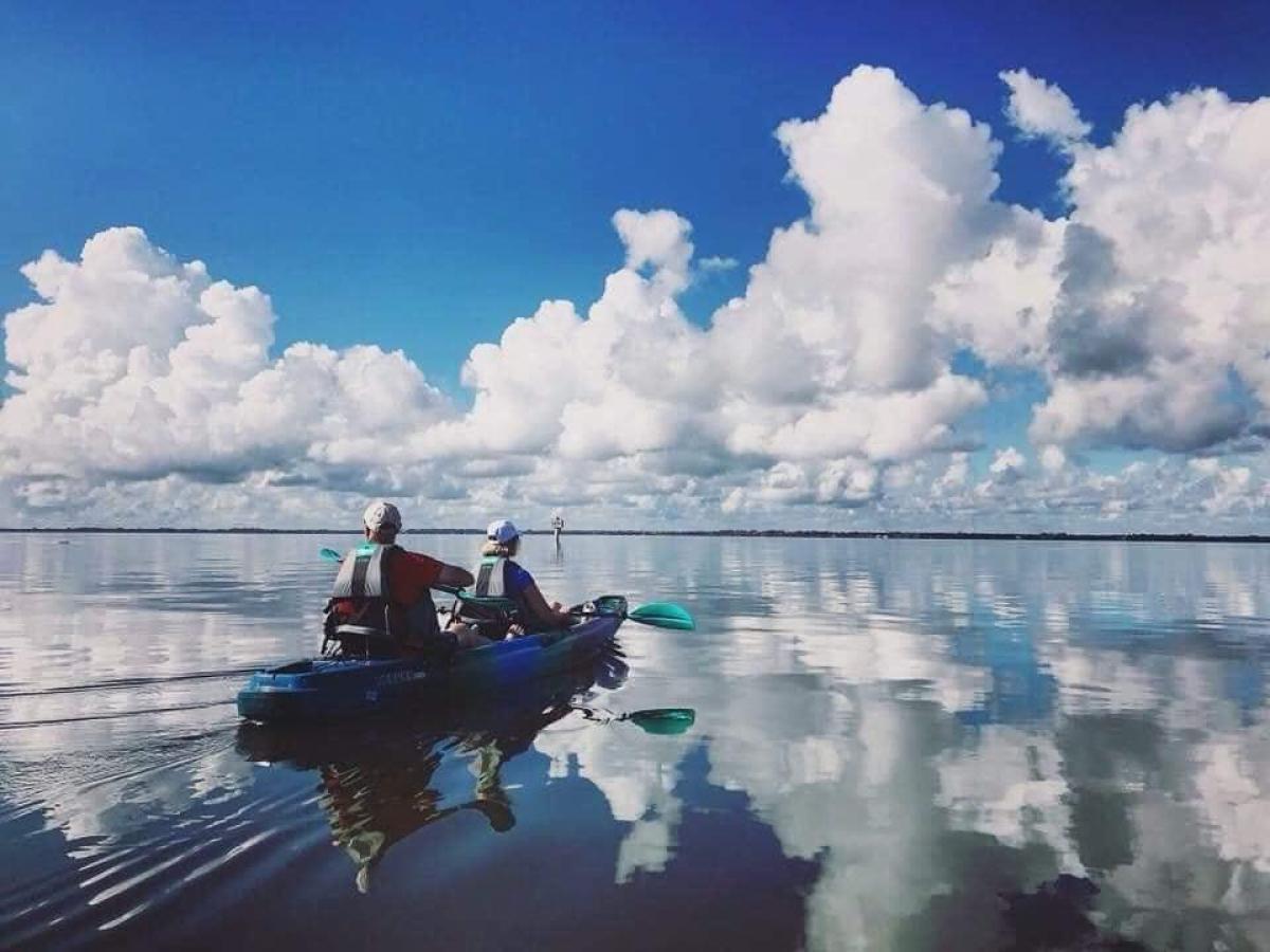 a group of people riding on the back of a boat in the water