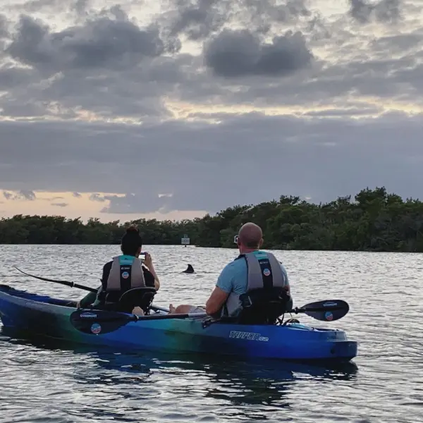 a man riding on the back of a boat in a body of water