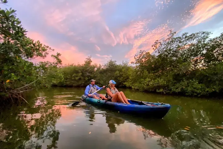 a man riding on the back of a boat in the water