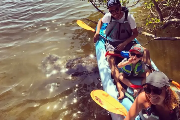 a man riding on the back of a boat in the water