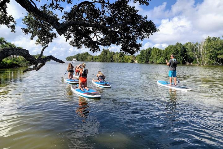 a group of people riding on the back of a boat in the water