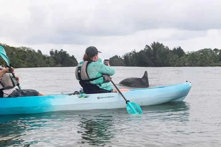 a group of people riding on the back of a boat in the water