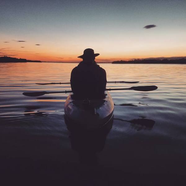 a man standing next to a body of water