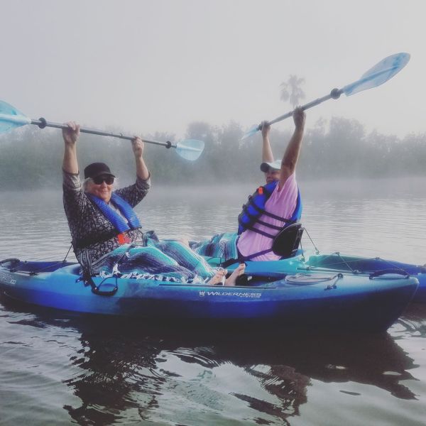 a group of people riding on the back of a boat in the water