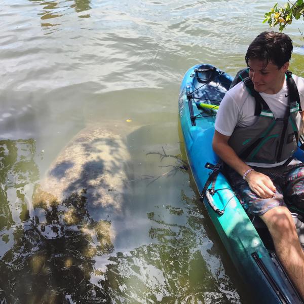 a man standing next to a body of water
