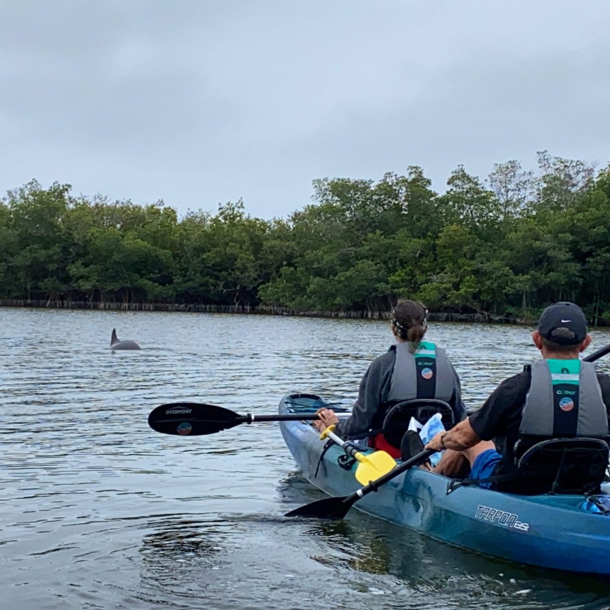 a man riding on the back of a boat in a body of water