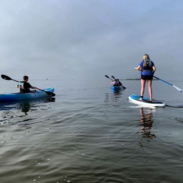 a group of people riding on the back of a boat in the water