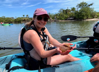 a woman sitting on a boat in a body of water