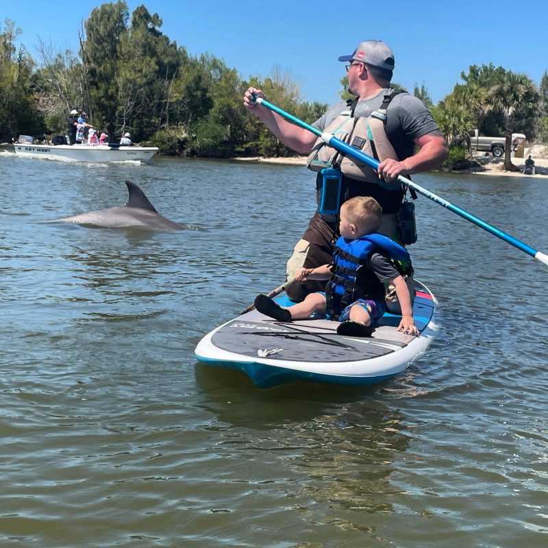 a man riding on the back of a boat in the water