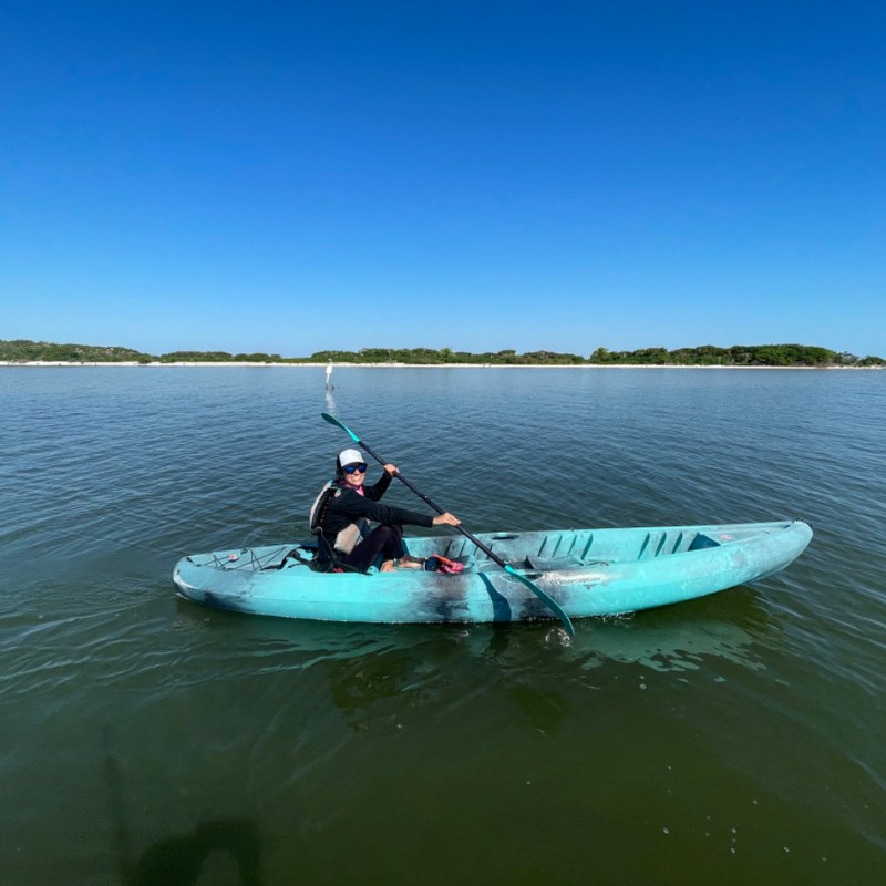 a man riding on the back of a boat in a body of water