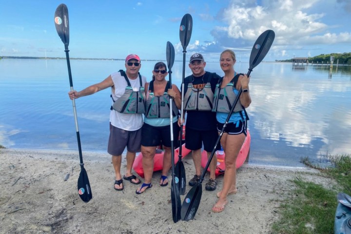 a group of people on a beach posing for the camera