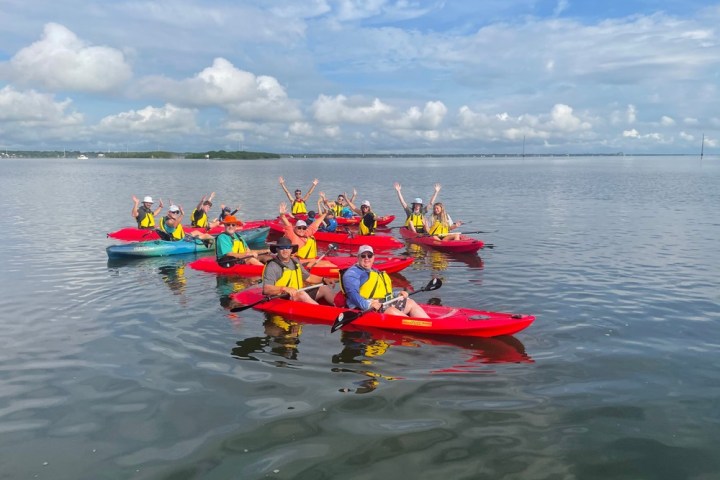 a group of people in a small boat in a body of water