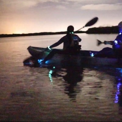 a man sitting next to a body of water