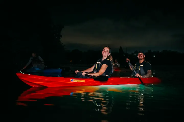 a man riding on the back of a boat in a body of water