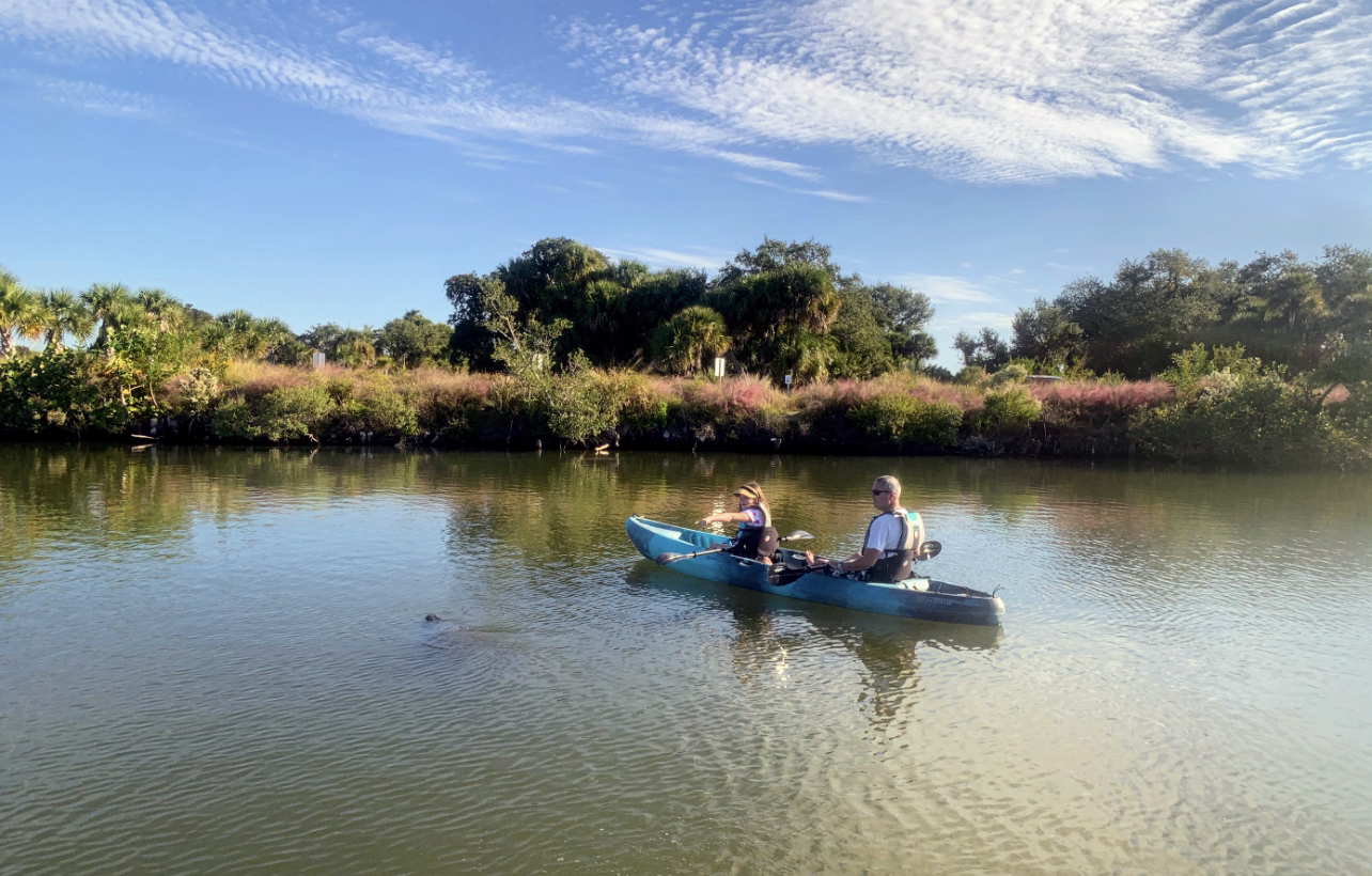 456BD63F-01EF-463A-BFDE-23384A42F643 a man riding on the back of a boat in a body of water