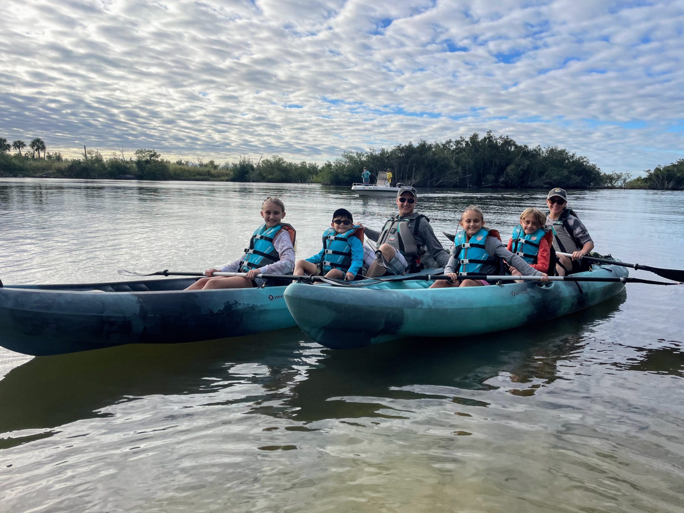DCB395D5-445E-4AFC-8E2D-8B3897F4D76D a group of people in a small boat in a body of water