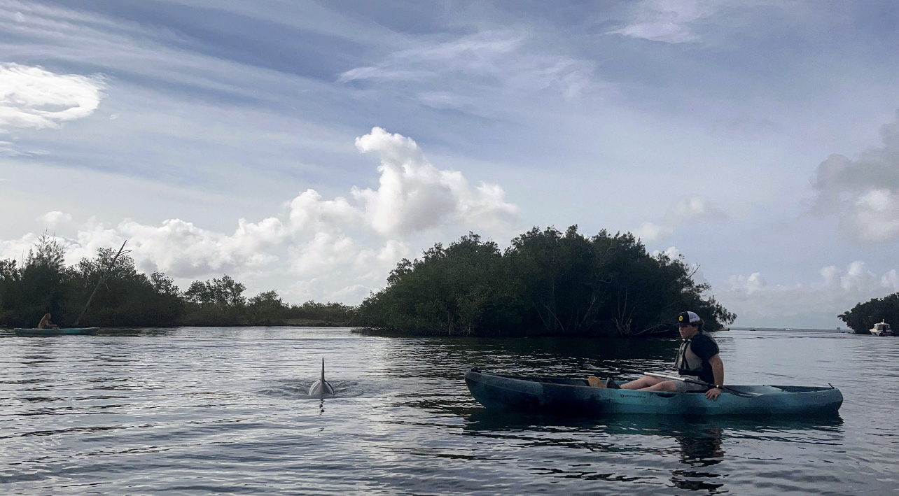 a group of people riding on the back of a boat in the water