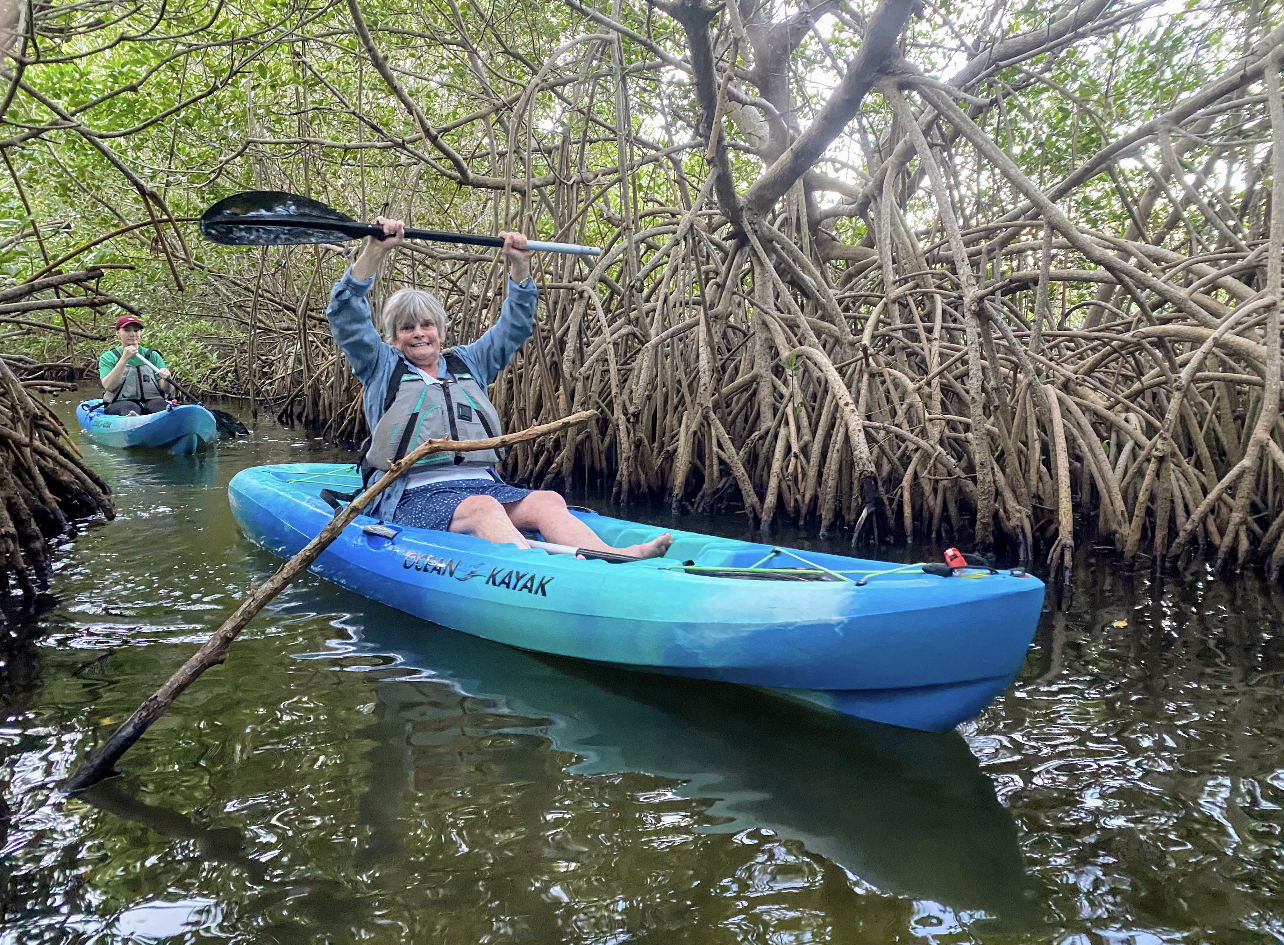 a group of people riding on the back of a boat in the water