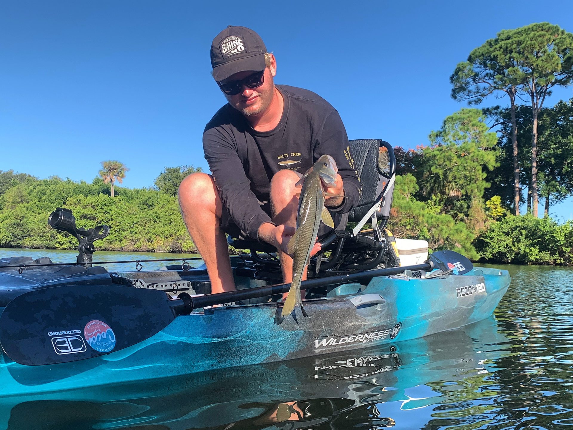 a man riding on the back of a boat in the water