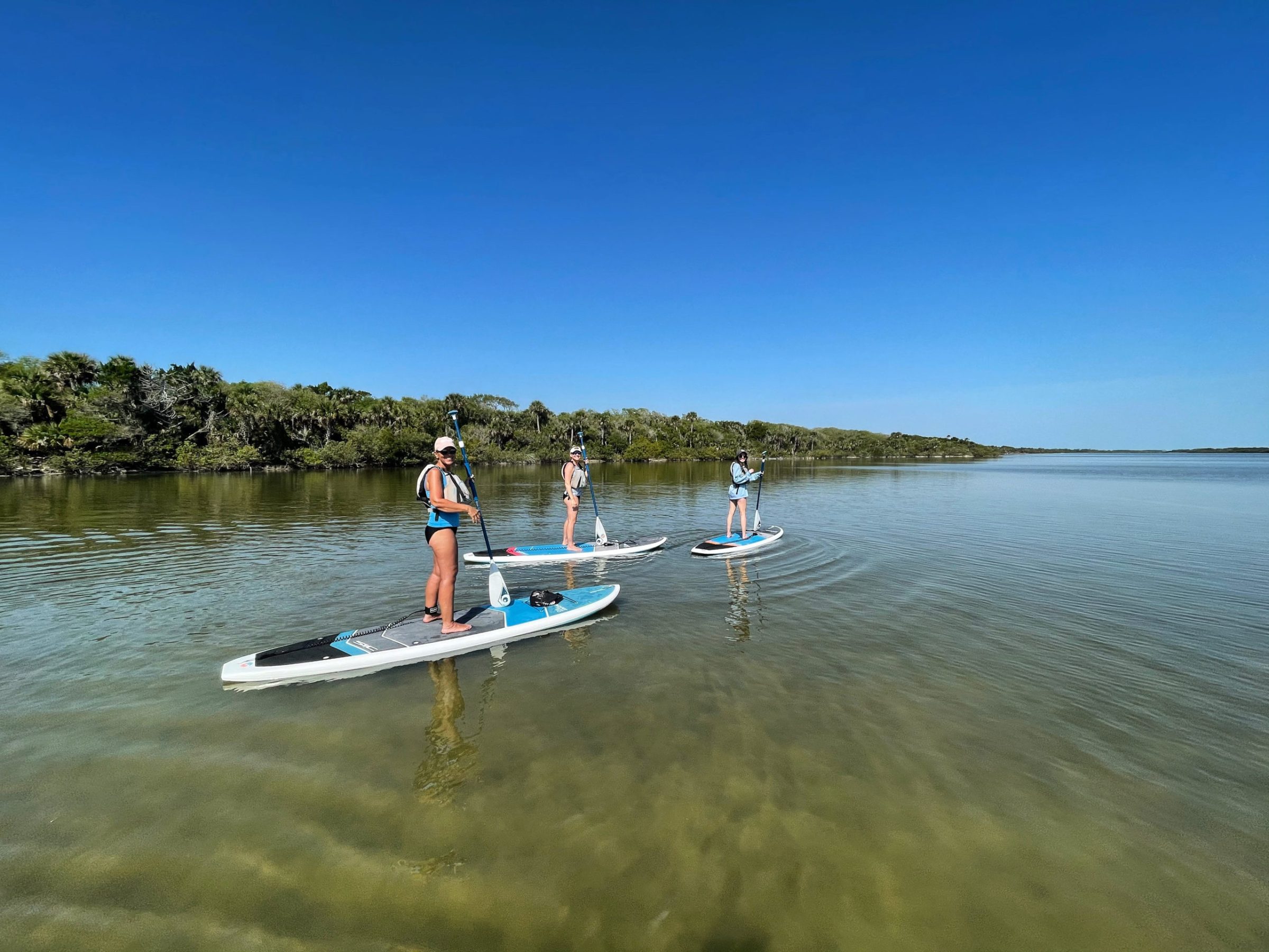 a group of people riding on the back of a boat in the water