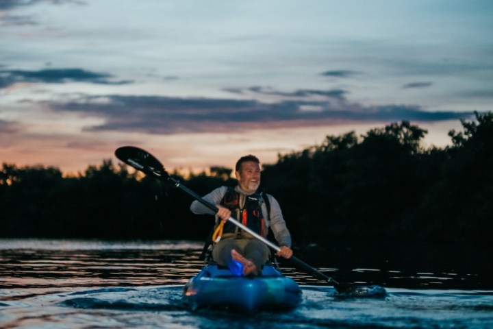 a man riding on the back of a boat in the water