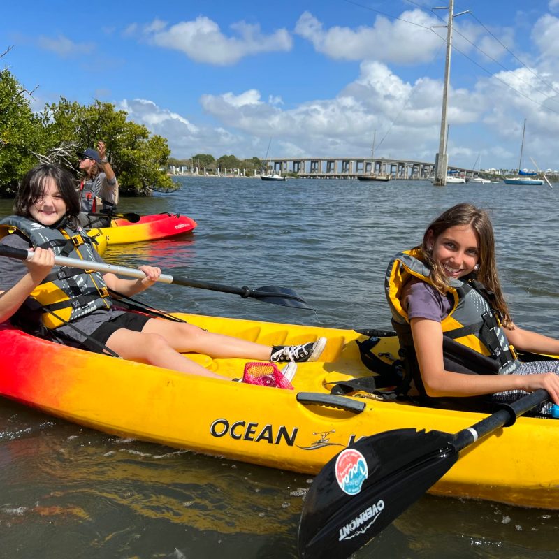 a group of people riding on the back of a boat in the water