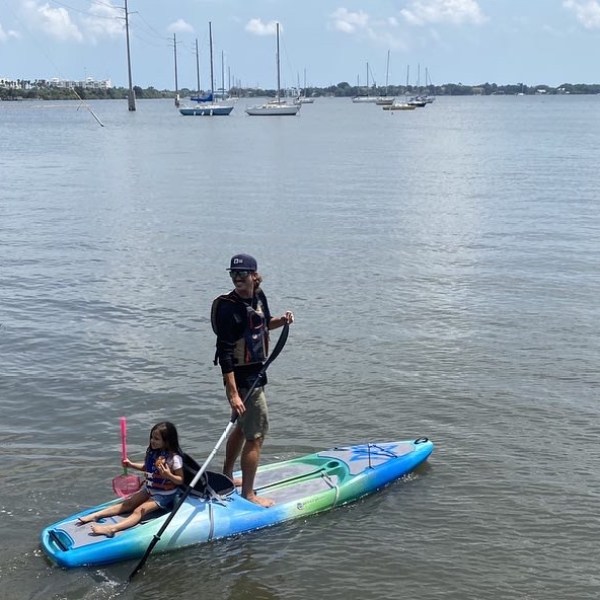 a man riding on the back of a boat in a body of water