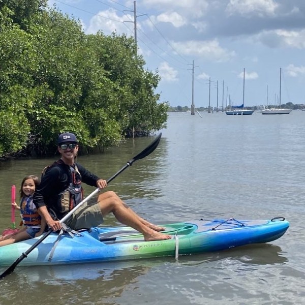 a little girl riding on the back of a boat in the water