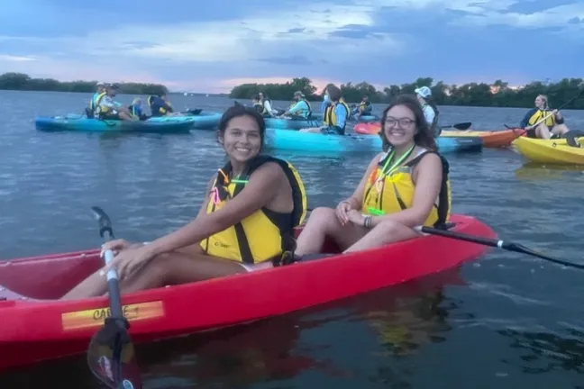 a woman with a small boat in a body of water