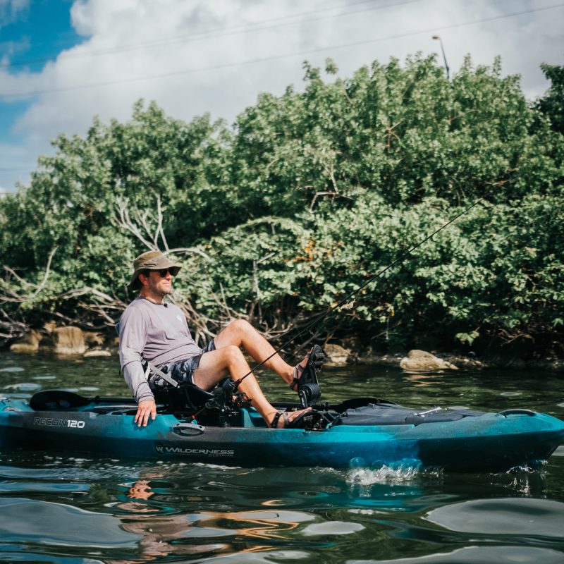 a man riding on the back of a boat in the water