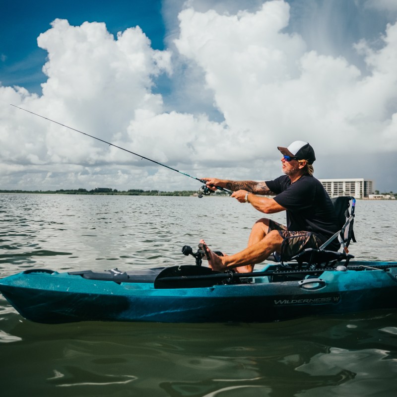 a man riding on the back of a boat in the water