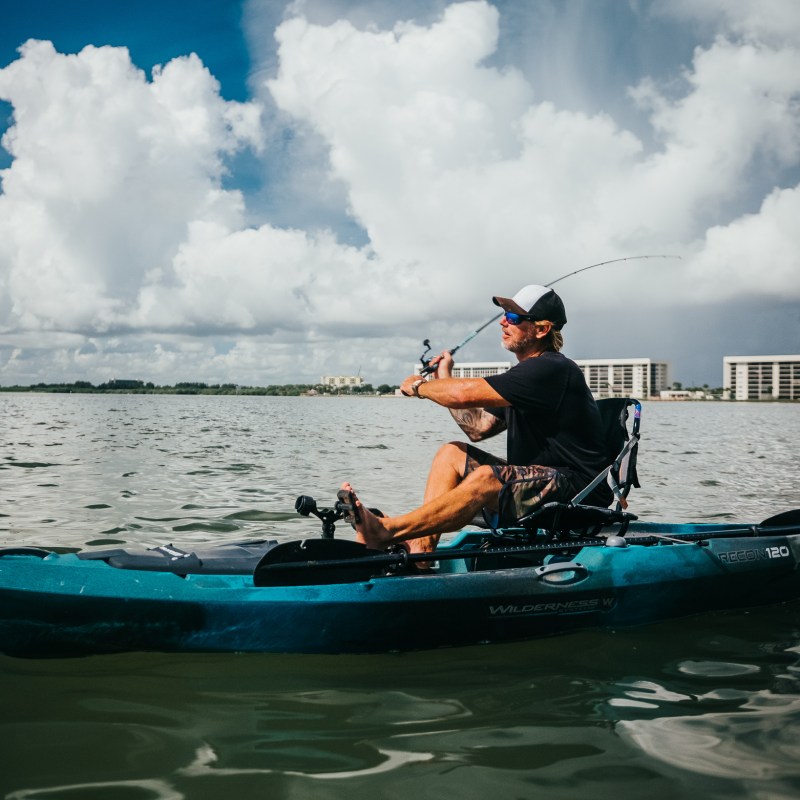 a man riding on the back of a boat in the water