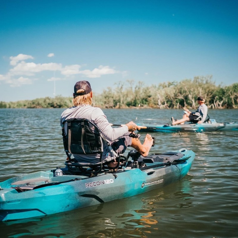 a man riding on the back of a boat in the water