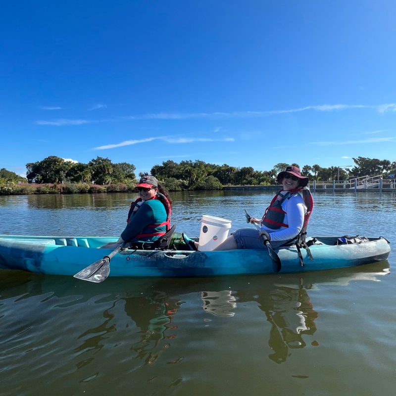 a group of people riding on the back of a boat in the water