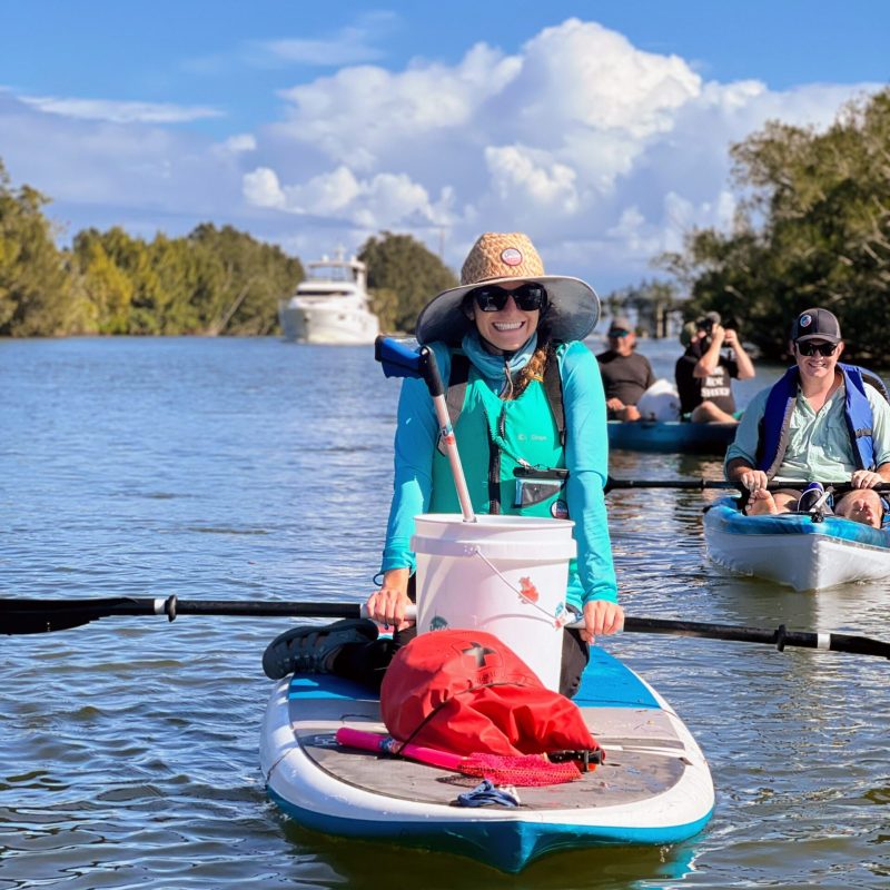 a group of people riding on the back of a boat in the water